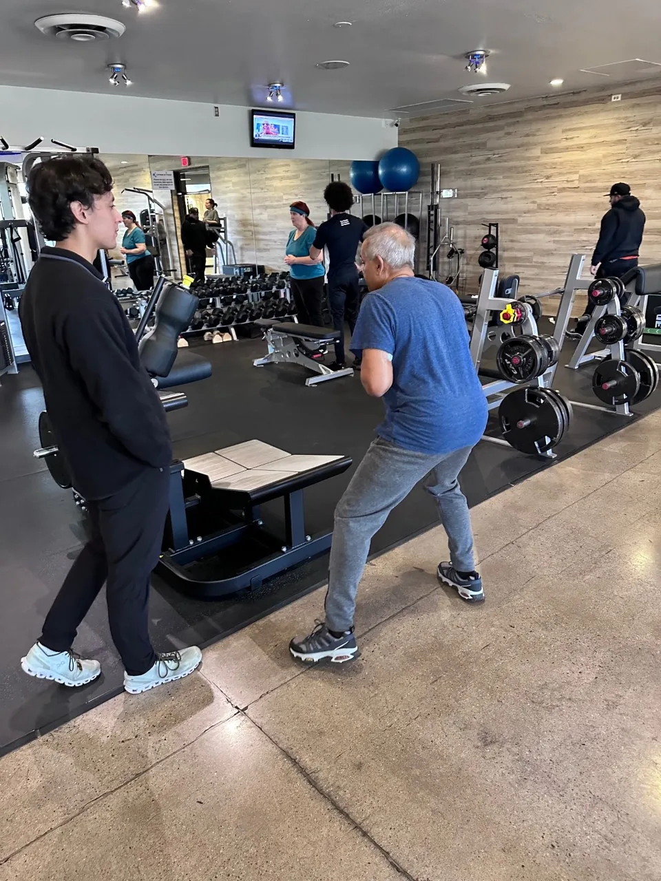 A Prestige Fitness coach guiding a client through an individualized strength session