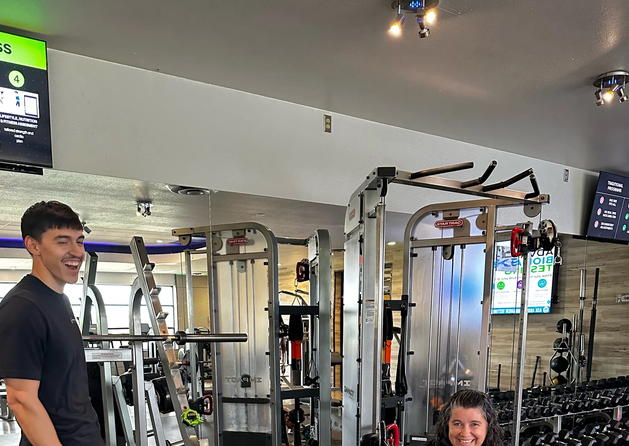 A Prestige Fitness client smiling through a coached cable session on the Tucson training floor